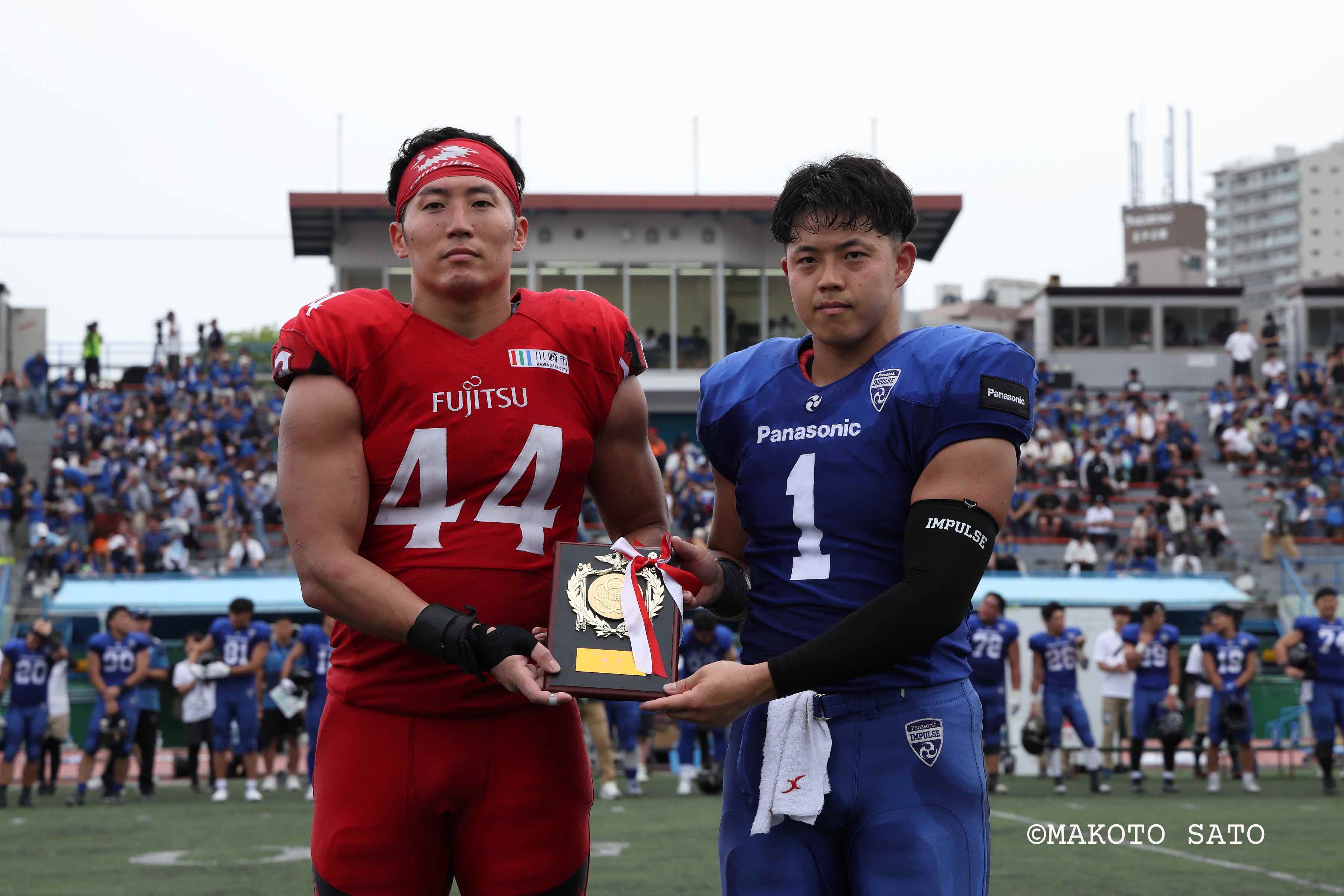 【アメフト第７３回神戸ボウル】引き分けで両チーム優勝となり楯を分け合うパナソニック・ 富士通の両主将 　写真：佐藤誠