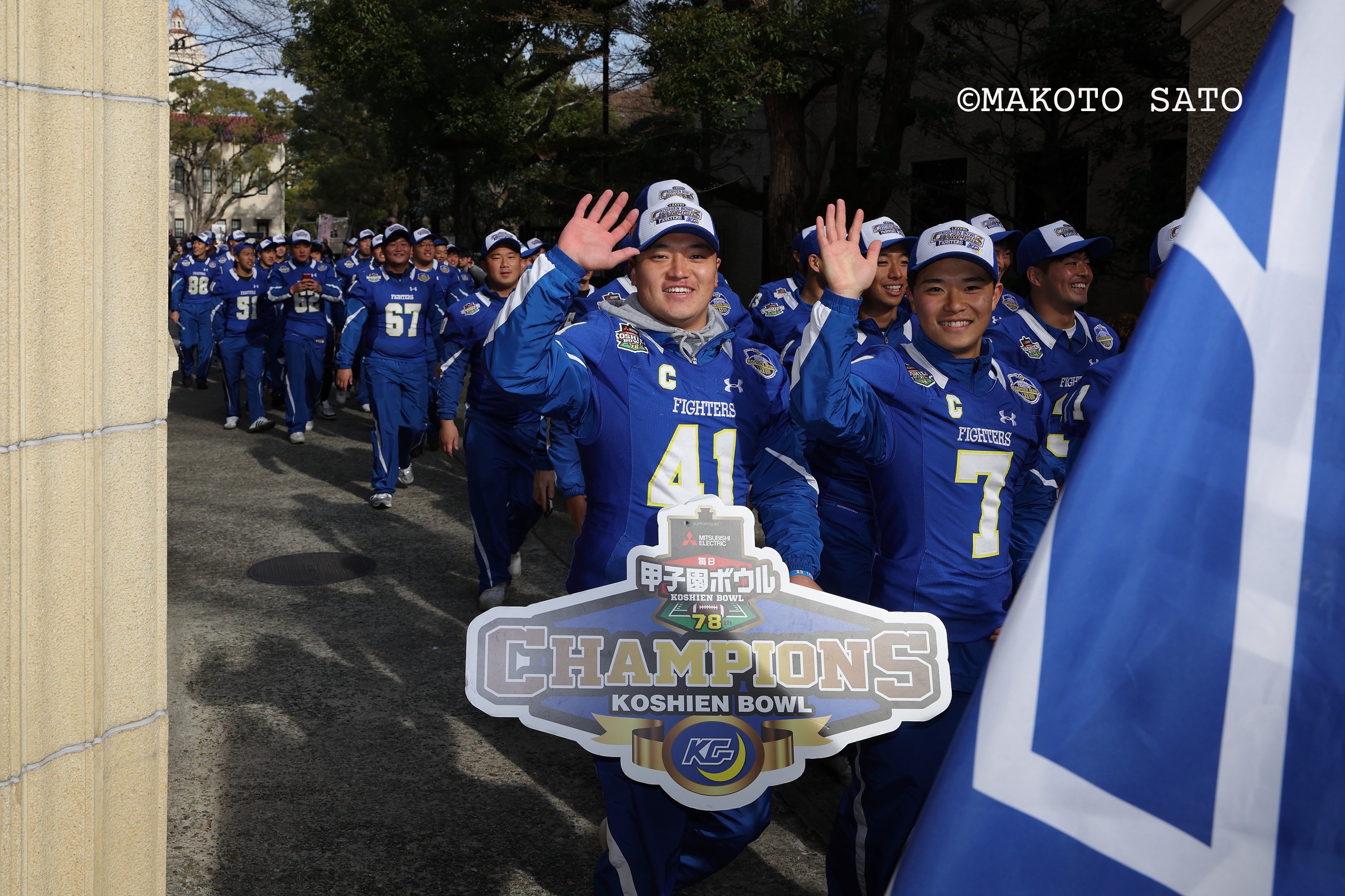 優勝祝賀パレードで手を振り学内を行進する海﨑琢主将、前島仁副将ら　写真：佐藤誠