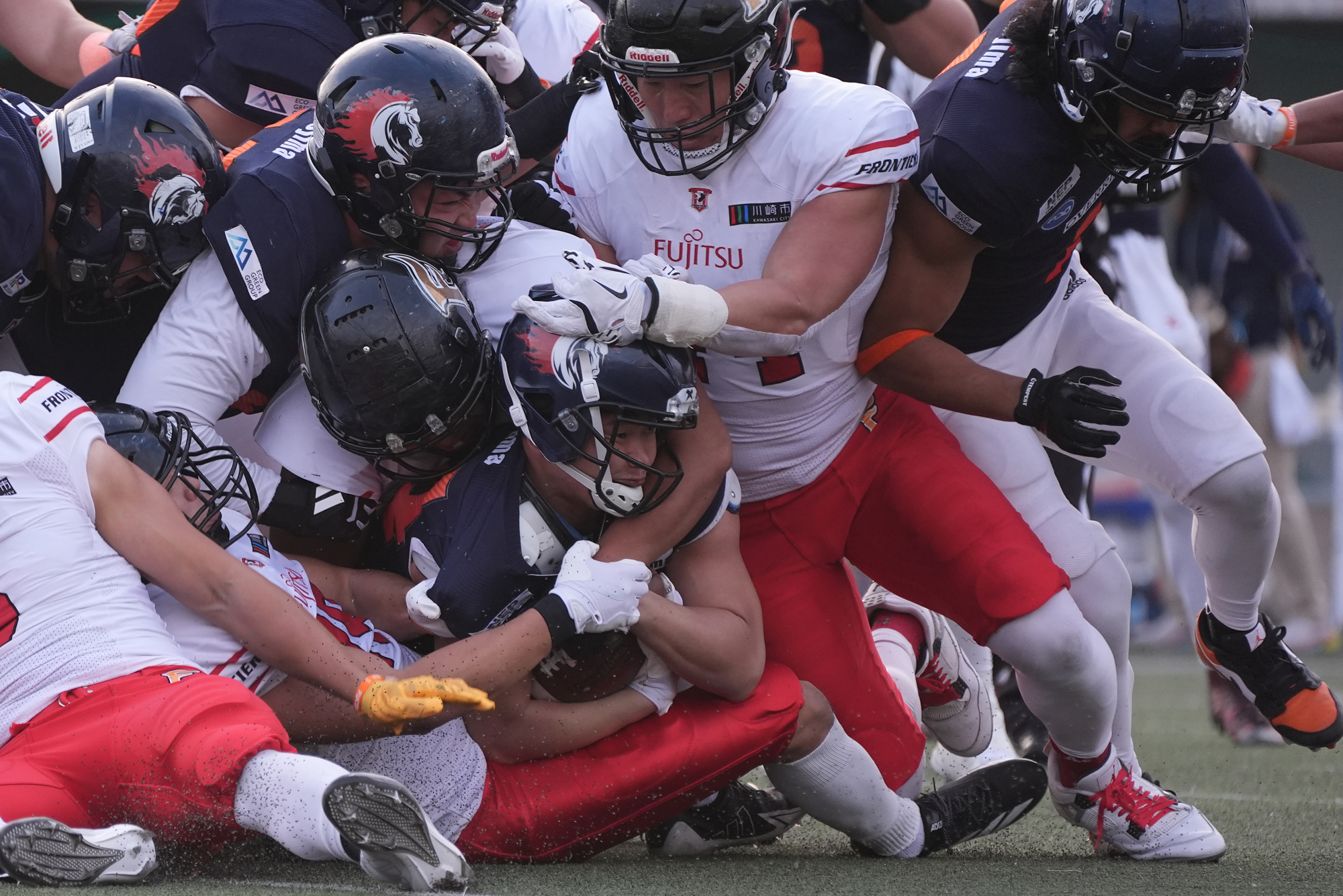 【富士通vsノジマ相模原】ノジマ相模原RB吉澤のランを押しつぶすようにして止める富士通ディフェンス陣=撮影:小座野容斉